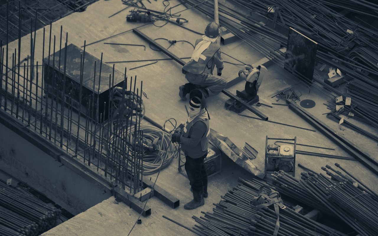 Crews placing rebar and decking on an active construction site